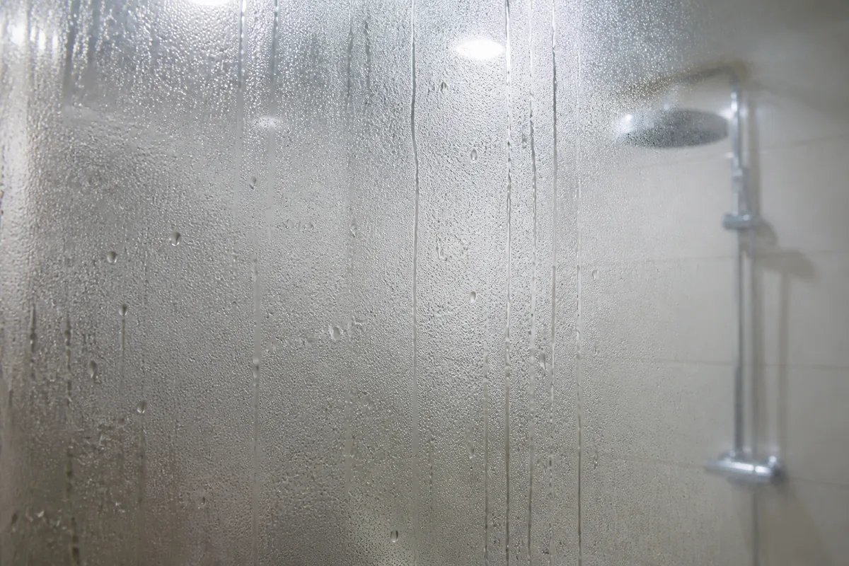 Condensation sur le miroir et les parois carrelées d une petite salle de bain sans ouverture